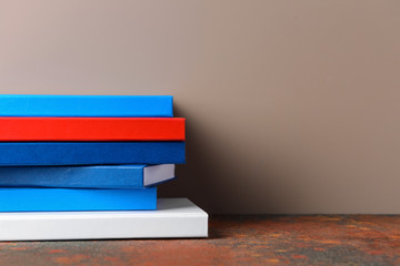 Many books on table against color background