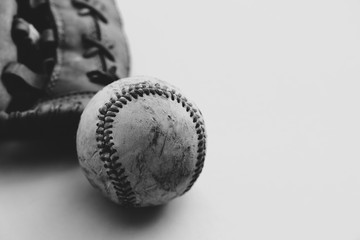 Black and white baseball with glove on isolated background.  Copy space for sports team graphic.