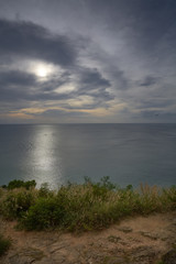 sunset skyline and seascape with hill and glass flower