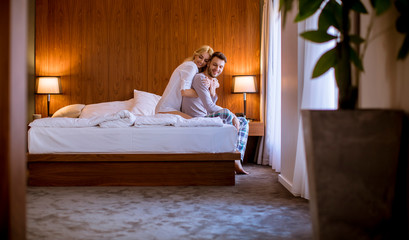 Lovely couple hugging on their bed at home