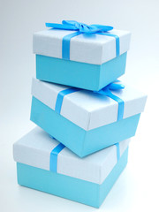 Three blue gift boxes with blue ribbon and blue bow