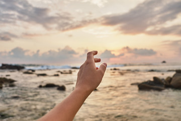 Girl reaches out to the clouds. Girl pulls her hand to the sea.