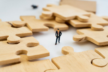 businessman concept sit on the jigsaw puzzle meaning of key success