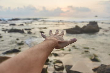 the guy reaches out to the clouds. The guy pulls his hand to the sea