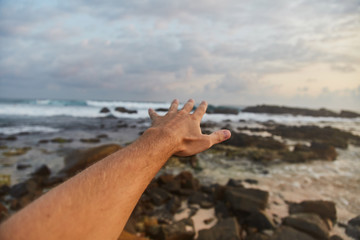 the guy reaches out to the clouds. The guy pulls his hand to the sea
