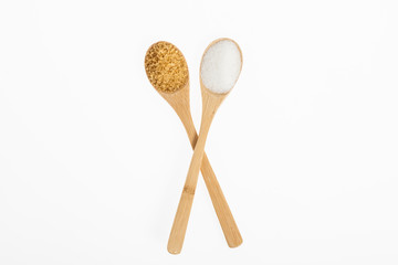 wooden spoons with white sugar and brown sugar on white background