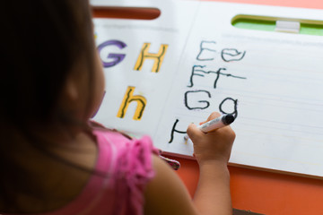 Kid learning how to write the abc's at home.