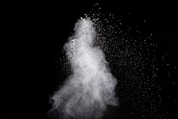 White powder explosion isolated on black background. White dust particles splash.