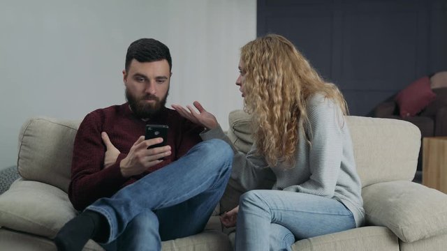 The girl screams at her boyfriend, who is typing on the phone