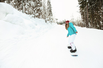 Sporty female snowboarder at winter resort