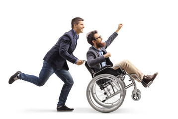 Young man running and pushing an excited man in a wheelchair gesturing with hand