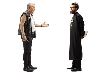 Mature male punker in a leather vest talking to a priest