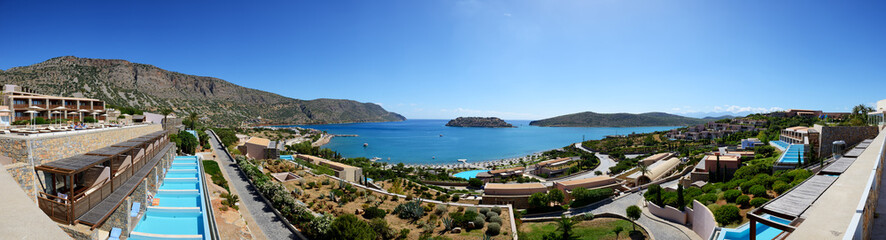 Naklejka na ściany i meble Panorama of swimming pools at luxury hotel with a view on Spinalonga Island, Crete, Greece