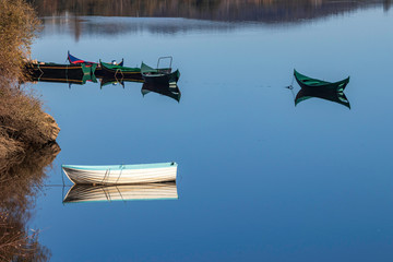 Small wooden boats with their reflection in the calm waters of the Tagus river, in ConstÃ¢ncia, Portugal. © Luis Fonseca