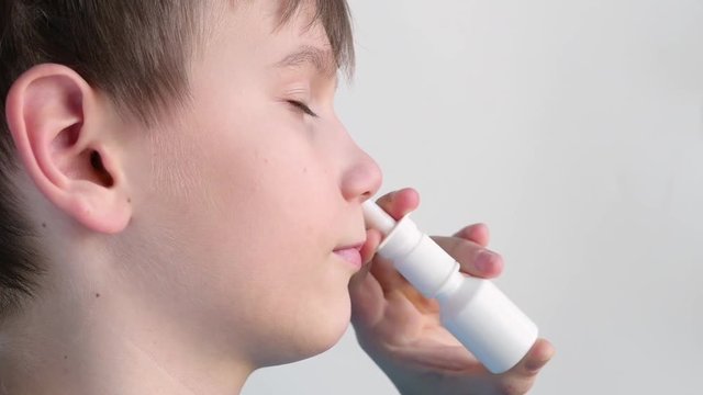 Boy using nasal spray and smiling
