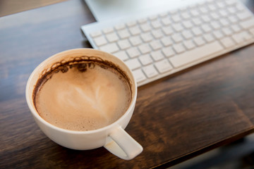 cup of coffee and laptop on table