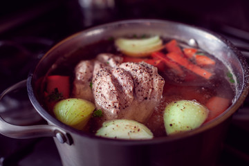 preparing a soup with a big part of meat, onions and carrots