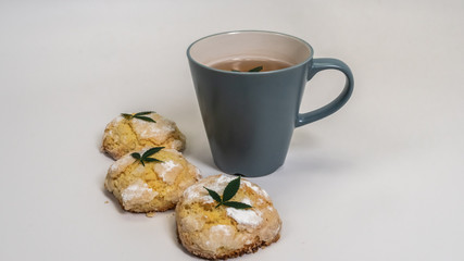 Homemade cupcakes (cake) with medical marijuana and a cap of tea with marijuana leaves on white background