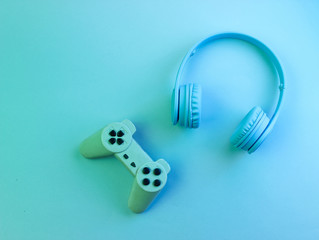 Gamer concept. Headphones and gamepad. Retro wave, neon light, ultraviolet. Top view, minimalism
