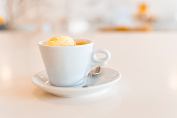 Affogato coffee with ice cream in a ceramic cup on a white wooden table