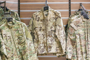 Fototapeta premium camouflage clothing for hunting and fishing on a hanger in the store