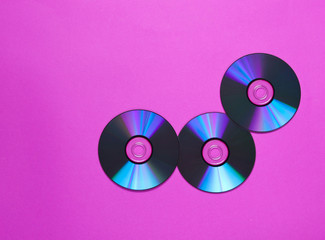 Three CD's on a pink background. Top view. .