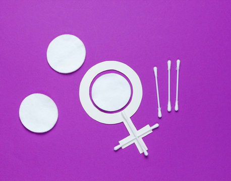 Products for feminine hygiene, self-care and health, female gender symbol on a purple background. Ear sticks, pads. Top view