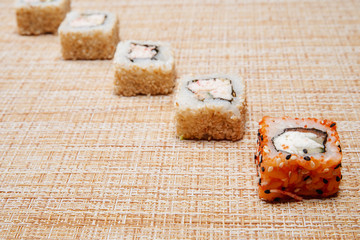 Sushi and rolls in wicker, a light background