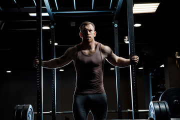Strong man posing in gym