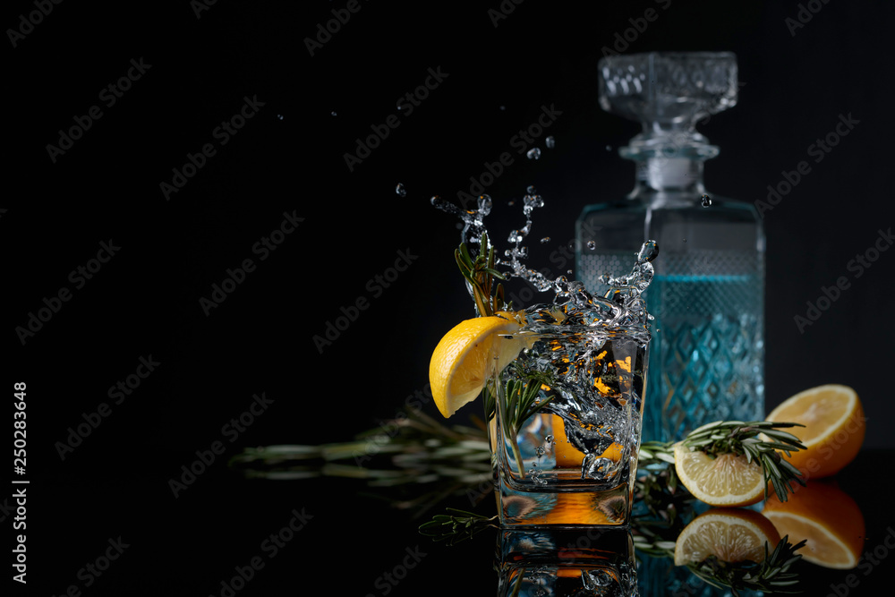 Poster cocktail gin-tonic with lemon slices and twigs of rosemary.