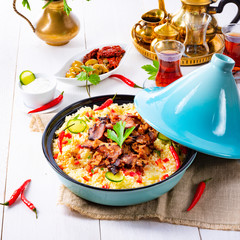 Tajin with couscous, vegetables and meat on white background