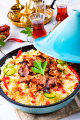Tajin with couscous, vegetables and meat on white background