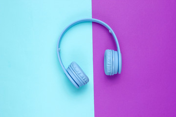 Modern Blue Wireless Over-Ear Headphones on a blue-purple background. Minimalism. Top view