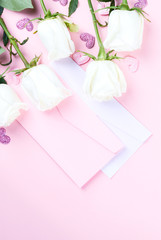 Valentines Day composition. Gift box, white rose flowers, envelope on pastel pink background. Mothers day, Womens Day Holiday concept. Flat lay, top view, copy space