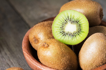 Kiwi in a wooden plate on a wooden table
