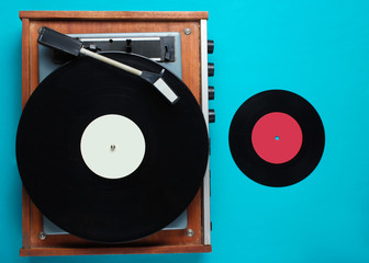Retro vinyl record player, lp record on blue background. Top view. Retro style. Flat lay.