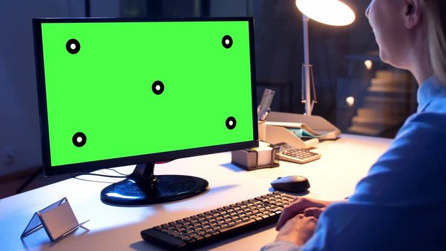 business, deadline and technology concept - businesswoman with chroma key green screen on computer monitor having video call at night office