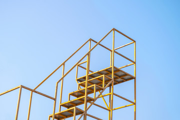 The handrail yellow steel stair with blue sky background