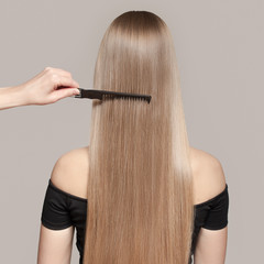 Portrait Of A Beautiful Young Blond Woman With Long Straight Hair. Back View