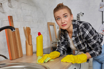 Young woman washing manually, by hand, wearing yellow cleaning rubber gloves.