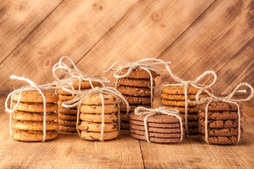 Various shortbread, oat cookies, chocolate chip biscuit on dark rustic wooden table.