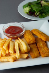 Closeup fish and chips with french fries - unhealthy food, grey backgrpound.
