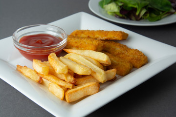 Closeup fish and chips with french fries - unhealthy food, grey backgrpound.