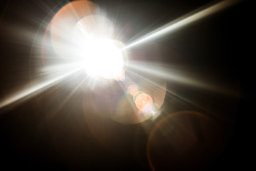 Lens Flare. Light over black background. Easy to add overlay or screen filter over photos. Abstract sun burst with digital lens flare background. Gleams rounded and hexagonal shapes, rainbow halo.