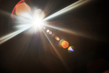 Lens Flare. Light over black background. Easy to add overlay or screen filter over photos. Abstract sun burst with digital lens flare background. Gleams rounded and hexagonal shapes, rainbow halo.