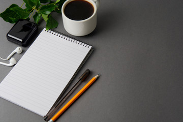 Creative flat lay of workspace desk. Top view office desk with notebooks and coffee cup on grey background. Top view with copy space. Minimalistic work space.