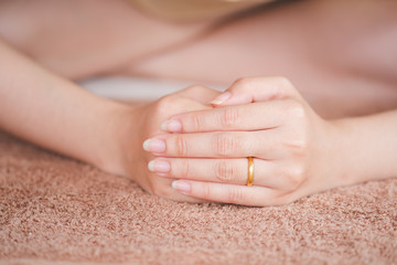 Gold ring on the ring finger of a woman, the concept of engagement or marriage.