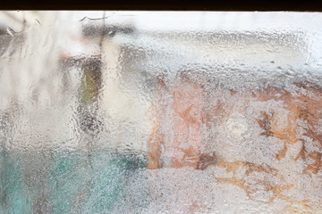 frosty pattern on glass winter window, look through glass 