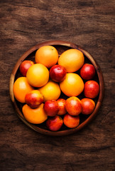 Bright fruits in large tray: oranges, lemons, mango in assortment. View from above