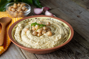 Delicious homemade hummus pasta with olive oil and chick-peas. Wooden table. Healthy food.